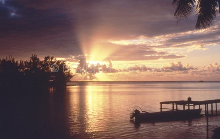 Sunset;colorful;sky;clouds;sun;water;boats;sillouettes;bridge;trees;ocean;moorea french polynesia